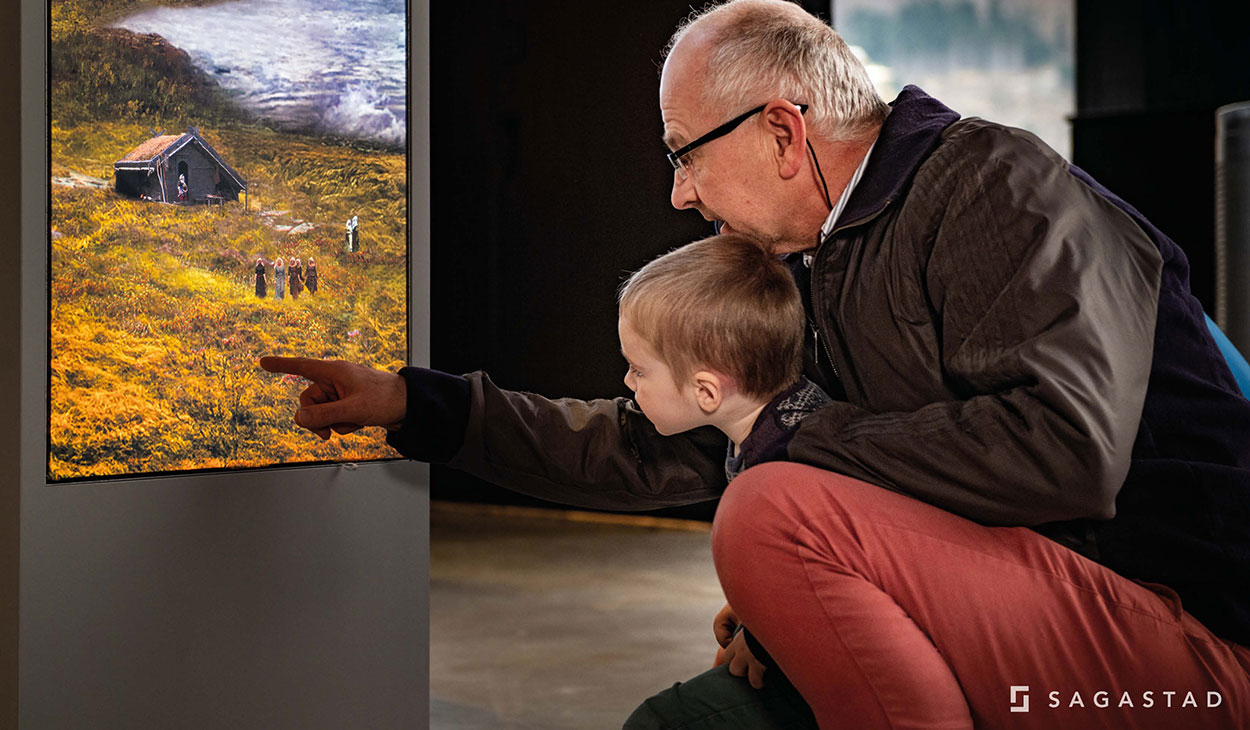 a child exploring the exhibition with his grandfather