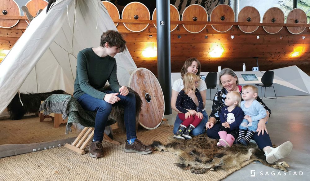 A family with children listening to the stories about the Norse Gods.